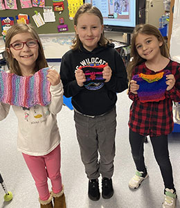 Students holding their crochet projects