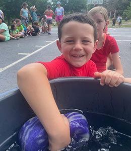 Student soaking a giant sponge in a bucket